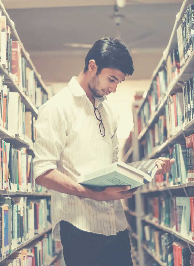 man reviewing books in a library